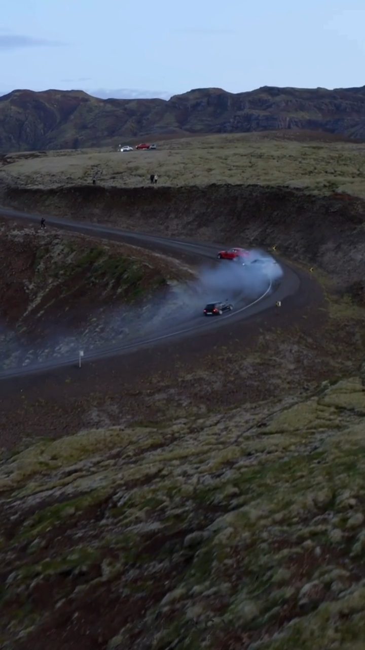Aerial frame of a road curving through a lava field